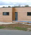 Vue extérieure de la maison ecologique en bois réalisée avec un mur pré-usiné (menuiseries intégrées)