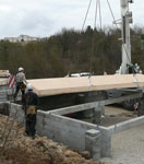 Pose du plancher en ossature bois sur les fondations de la maison