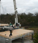 Pose du deuxième plancher en ossature bois sur les fondations de la maison