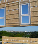 Chantier d'une construction en bois avec la pose d'un mur préfabriqué