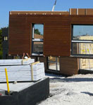 Chantier d'une construction bois : pose du mur préfabriqué