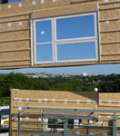 Chantier d'une construction bois avec la pose d'un mur préfabriqué