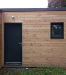 Vue de la porte d'entrée, d'une menuiserie extérieure, sur une maison bois ECOP Habitat